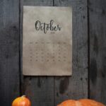 Rustic October 2020 calendar with pumpkins on a wooden background, evoking a fall atmosphere.