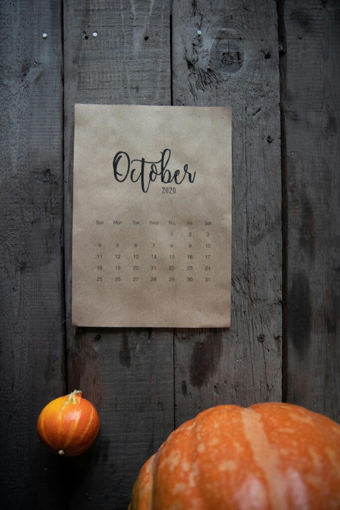 Rustic October 2020 calendar with pumpkins on a wooden background, evoking a fall atmosphere.